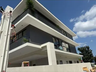 Exterior view of a modern low rise builder floor building with a balcony.
